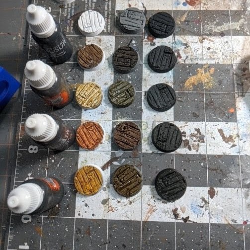 The twelves bases painted to showcase contrast paint at three different undercoats.