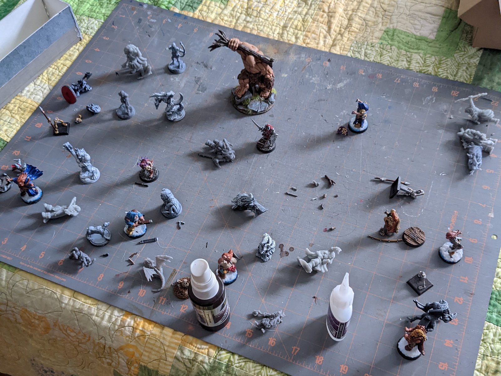 Cutting mat with broken miniatures and superglue to repair the models